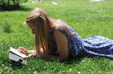 Frau lesend im Gras