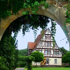 Blick durch den Mauerbogen aufs Rathaus Gieselwerder