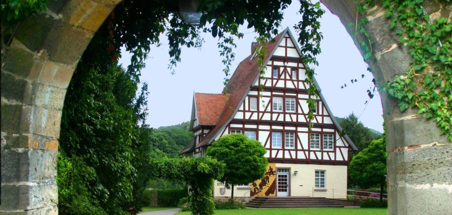 Blick durch den Mauerbogen aufs Rathaus Gieselwerder